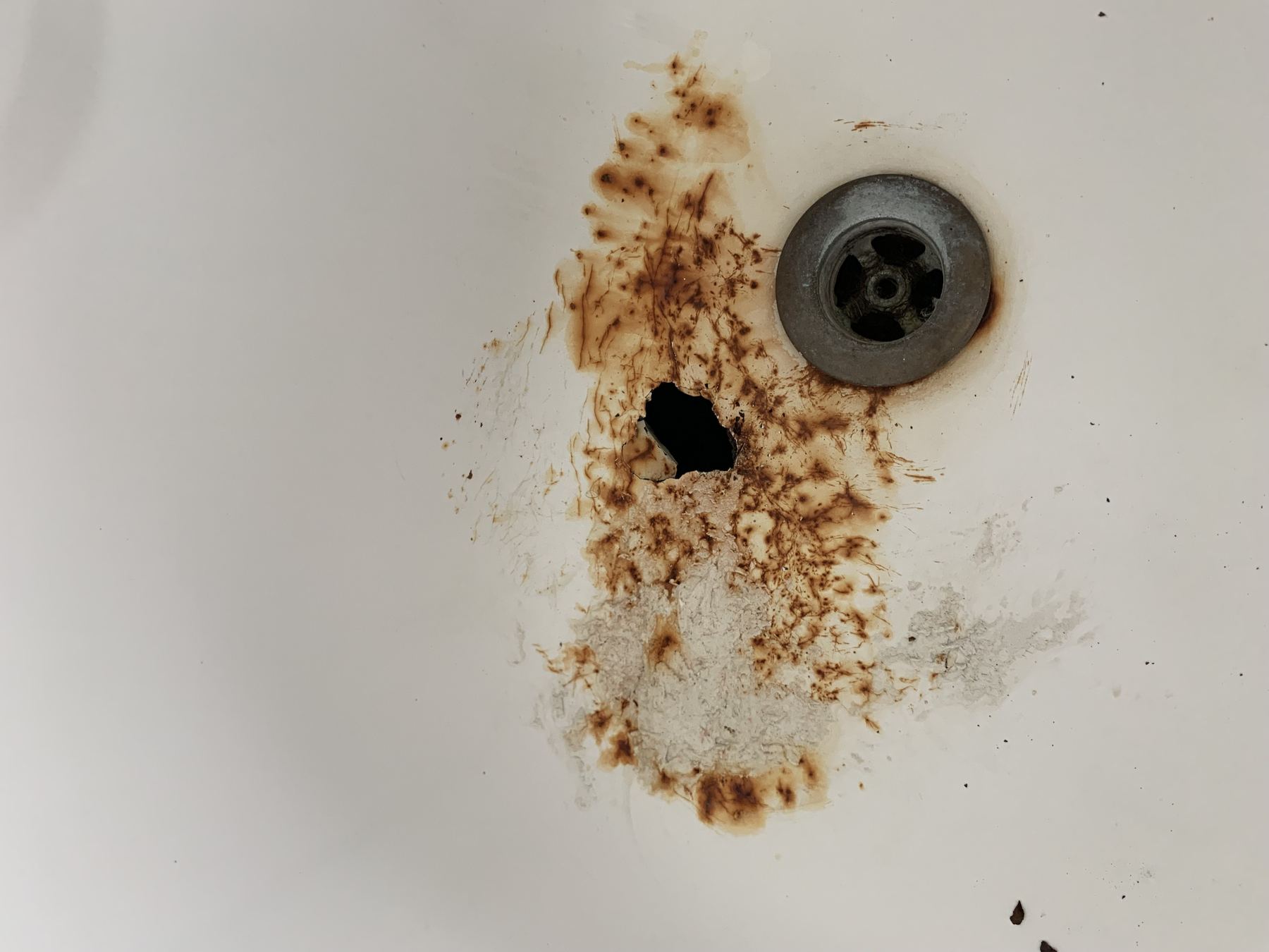 Bathtub crack near drain before repair.